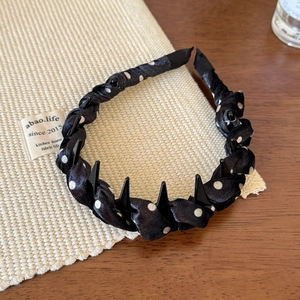 Détail des dents antidérapantes sur ce serre-tête noir en satin à pois blancs