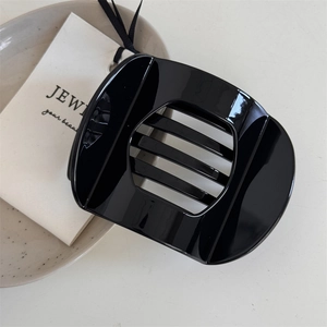 Sleek black glossy hair claw clip featuring a minimalist hollowed striped rectangular design