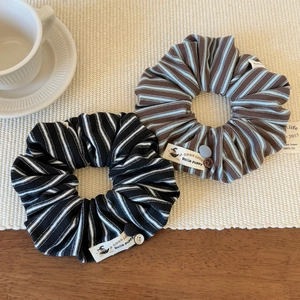 Chouchous en tissu rayé avec boutons décoratifs sur un tapis tissé