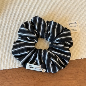 Détail d'un chouchou à rayures noires et blanches avec étiquette en tissu Bella Puppy