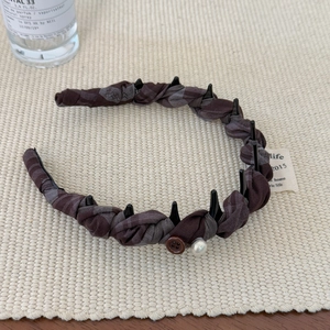 Vue détaillée du serre-tête en tissu avec bouton marron rétro et décoration en perle