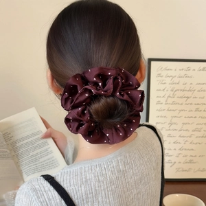 Elastico per capelli bordeaux a doppio strato con pois bianchi su uno chignon