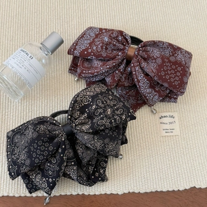Retro paisley bow hair clips in coffee and black colors with elegant weaving background