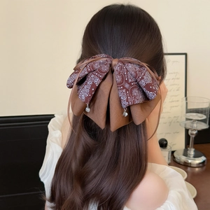 Retro brown paisley double bow hair claw clip with crystal pendants on a model