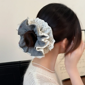 Elegant oversized grey and cream lace scrunchie styled on a classic bun hairstyle
