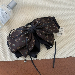 Vintage floral bow hair clip with dark brown pattern and elegant black satin ribbon detail
