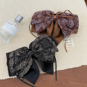 Elegant paisley bow hair clip in brown and black styles for vintage hairstyle look