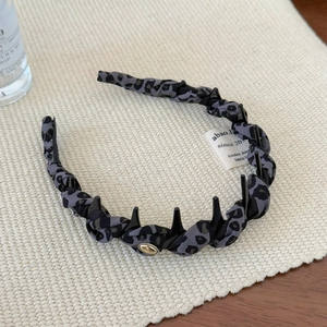 Détail du serre-tête léopard avec dents antidérapantes et petite boucle en métal doré