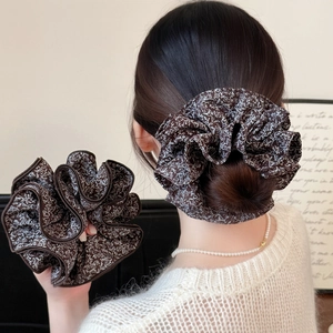 Detail showing deep brown floral scrunchie with white flower print and brown piping edge