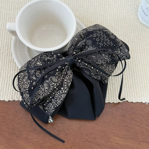 Detail of vintage black paisley bow hair claw with elegant ribbon and bead pendants