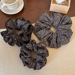 Three-piece vintage brown floral scrunchie set with delicate pattern on woven mat