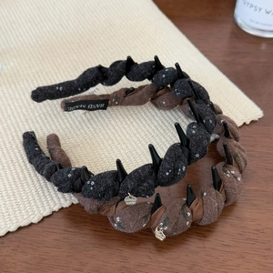 Close-up of twisted fabric headband with non-slip teeth and handmade label detail