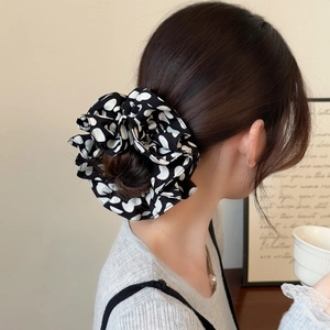 Chouchou noir chic avec pois blancs en cœur pour coiffure élégante en chignon