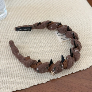 Brown twist fabric headband with floral embroidery, inner teeth and handmade label