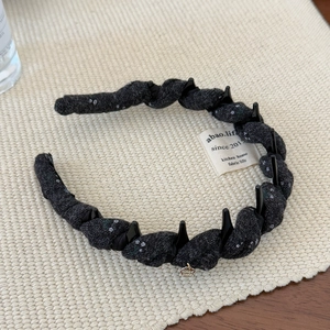 Detail of twisted fabric headband with anti-slip teeth and handmade silver charm