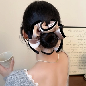 Chouchou élégant en satin rose champagne avec bordure en velours noir sur un chignon
