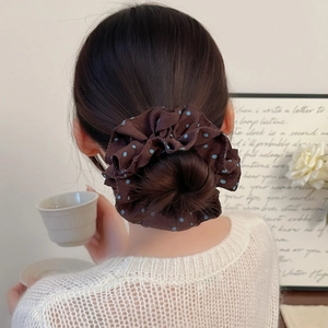 Coffee and blue polka dot scrunchie with pleated chiffon texture on a hair bun