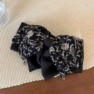 Vue macro d'un nœud en satin floral français avec détail pendentif en strass