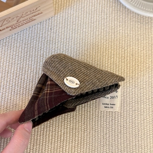 Dreieckige Strick-Haarklammer in Braun und Burgunder-Karo mit weißem Knopf-Detail