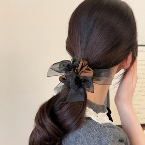 Elegant layered organza and satin bow hair scrunchie shown on a woman from a side-view angle