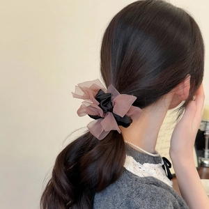 Elegant layered satin and organza scrunchie hair tie on a low ponytail back view