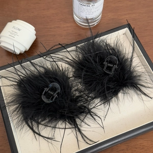 Lot de pinces à cheveux élégantes en plumes noires présentées sur un plateau de luxe