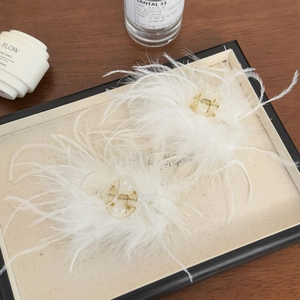 Élégante paire de pinces à cheveux en plumes blanches avec texture douce et ressort doré