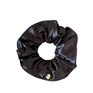Chouchou élégant en satin noir brillant avec texture soie et pendentif métallique doré