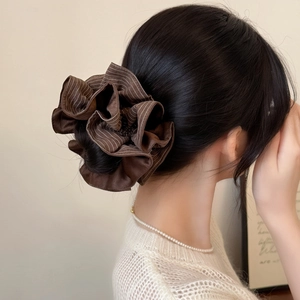 Brown striped oversized scrunchie hair tie styled on a low bun for women