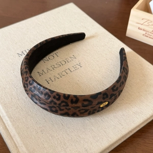 Chic leopard print headband with a golden metal logo plaque for women in vintage style