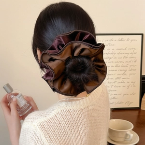 Detailed shot of a large brown and burgundy velvet scrunchie on a bun hairstyle