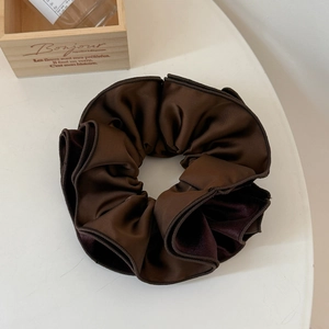 Detailed view of large coffee brown pleated velvet scrunchie with silky satin texture