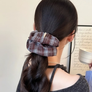Retro brown plaid scrunchie hair tie shown in a stylish hairstyle on a model back view