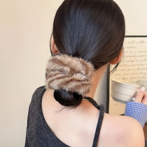 Détail de la texture d'un chouchou en peluche à rayures de tigre marron sur cheveux