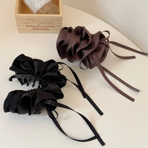 Vue détaillée de grandes barrettes nœuds en satin plissé de couleurs noir et marron foncé