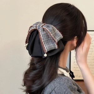 Vintage checkered and black satin bow hair claw clip with pearls on half-tied hairstyle