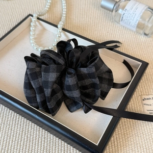 Detail view of plaid fabric hair clip with multilayered texture and elegant vintage style