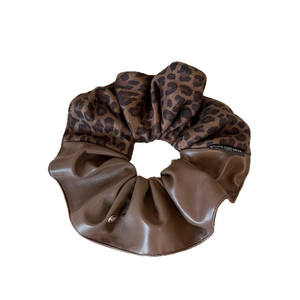 Brown leopard print fabric and faux leather scrunchie with gold accent and woven label