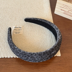 Close-up of dark grey leopard print velvet headband with black non-slip lining