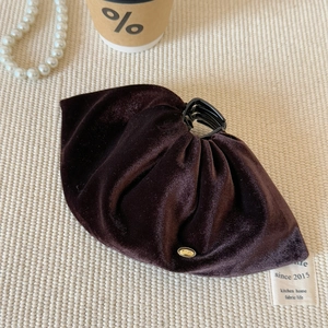 Vue détaillée de la pince à cheveux de luxe en velours marron foncé avec logo doré