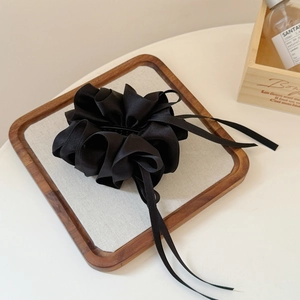 Détail du nœud papillon en ruban de satin noir plissé multicouche pour queue de cheval