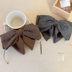 Detail view of vintage plaid bow hair clips featuring elegant pearl pendants for women