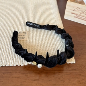Detail of black velvet braided headband with pearl, gold charm and handmade tag