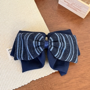 Vue détaillée de la barrette à double nœud bleu marine avec tissu en maille rayée
