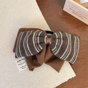 Détail de la pince à cheveux noeud tricoté rayé avec couches de tissu sur set de table