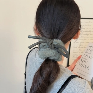 Détail d'un chouchou nœud en fausse fourrure gris-vert pour une queue de cheval chic