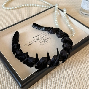 Detailed close-up of a black velvet braided headband with rhinestones and non-slip inner teeth