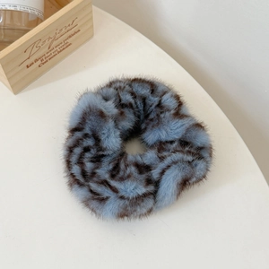 Gros plan du chouchou en peluche imprimé léopard bleu-gris à texture douce