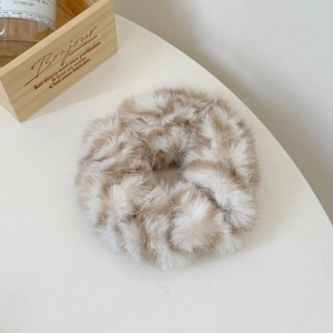Détail d'un chouchou en peluche à motif léopard avec texture douce en fausse fourrure