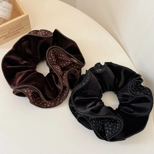 Detail showing plush velvet scrunchies in brown and black with floral fabric accents